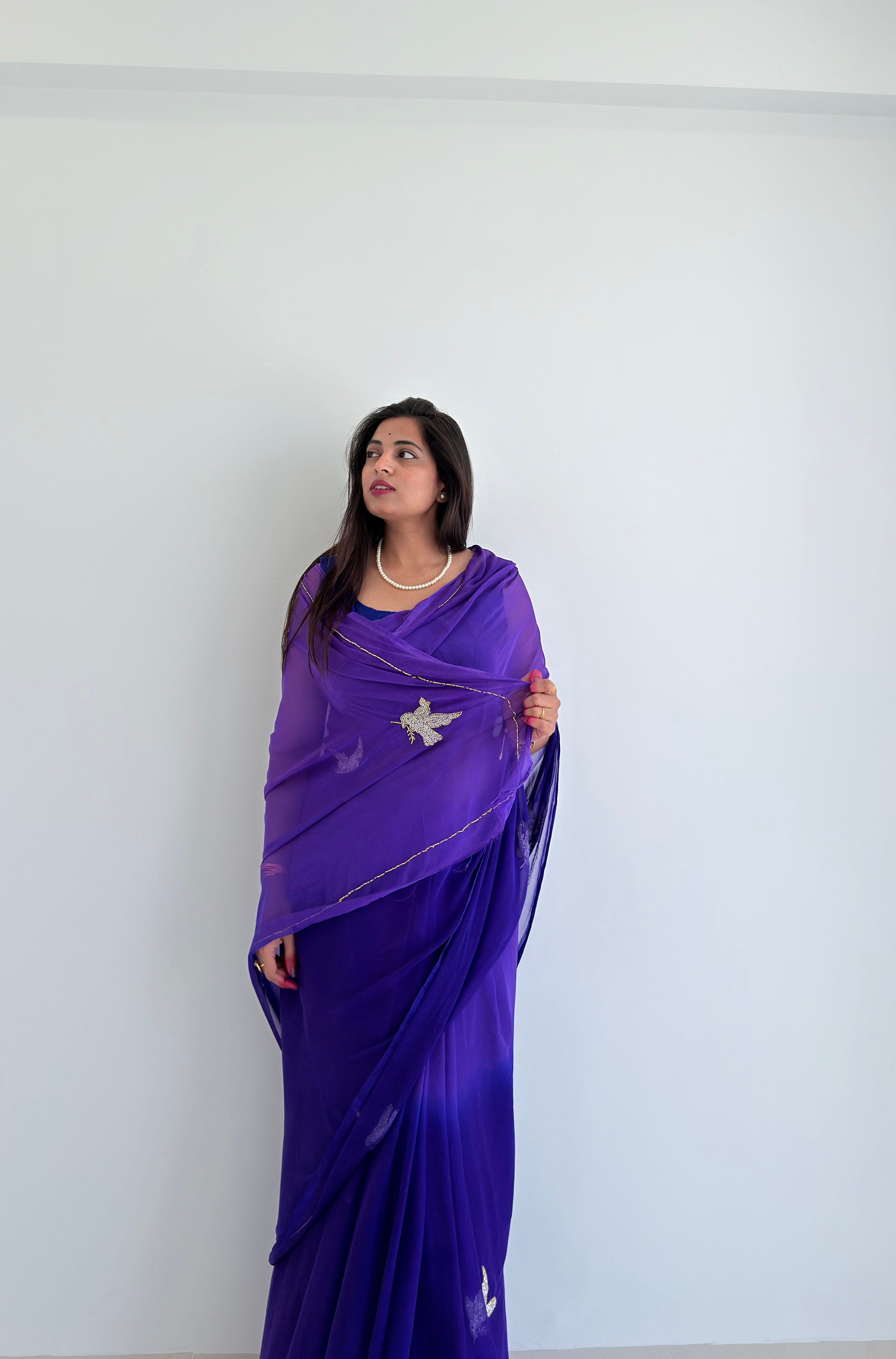 An exquisite purple chiffon saree with intricate bird embroidery, designed to add effortless elegance to your wardrobe